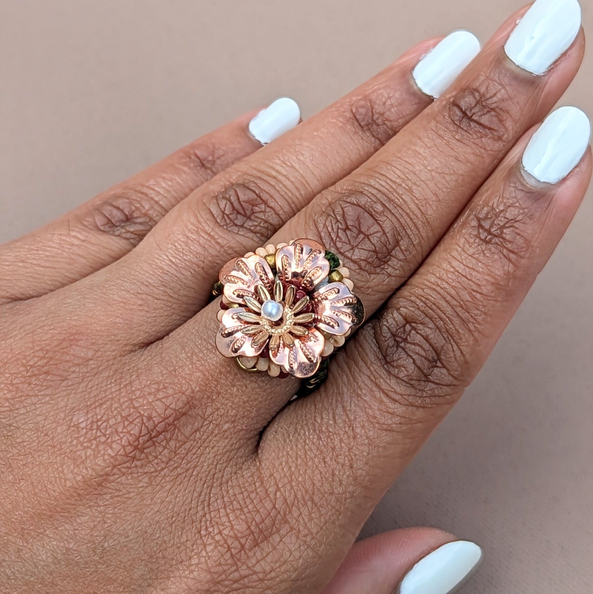 A bold statement Indian inspired ring featuring a large rose gold plated flower with a small central gold plated flower at the centre of which lies a lustrous pearl seed bead. This adjustable ring is designed for comfort so enchanting you might forget you are wearing it everyday, at weddings or on special occasions. Exclusively from sustainable UK brand Mayaani Jewellery.