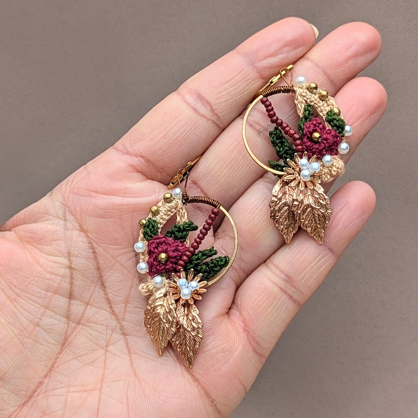 Sustainably handcrafted Indian earrings in red, green, and gold by UK Indian Jewellery designer and artisan Megha of Mayaani Jewellery UK. Featuring 14K gold plated hoops, these lightweight earrings combine traditional artistry with delicate floral crochet details for modern elegance.