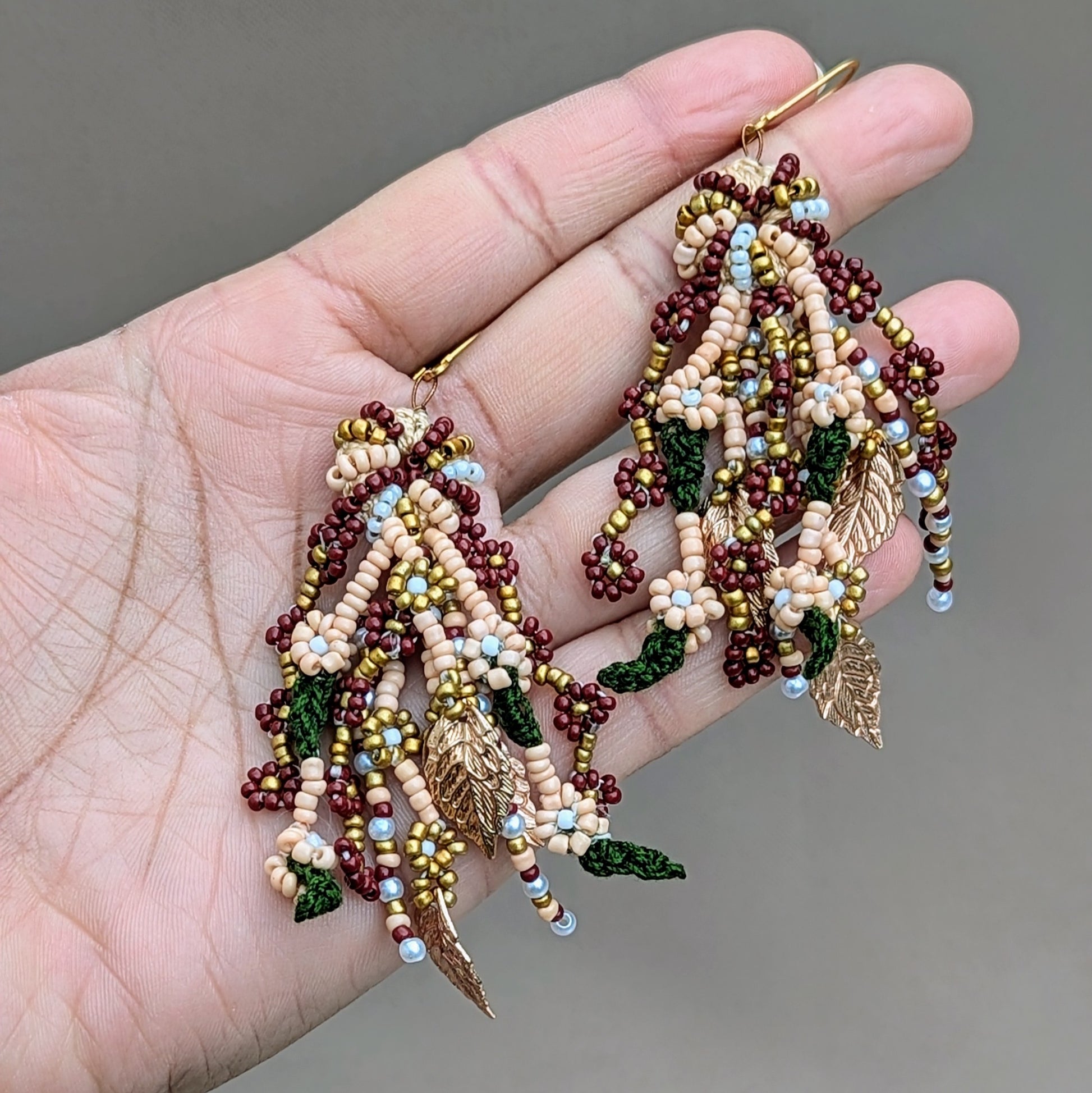 These beautifully designed lightweight earrings highlight expert craftsmanship and comfort unique to sustainable brand Mayaani Jewellery UK. Inspired by Indian bridal elegance, they feature bright red, green, and gold accents along with seed pearls. With intricate gold leaf details, they embody the grandeur of India’s traditions.