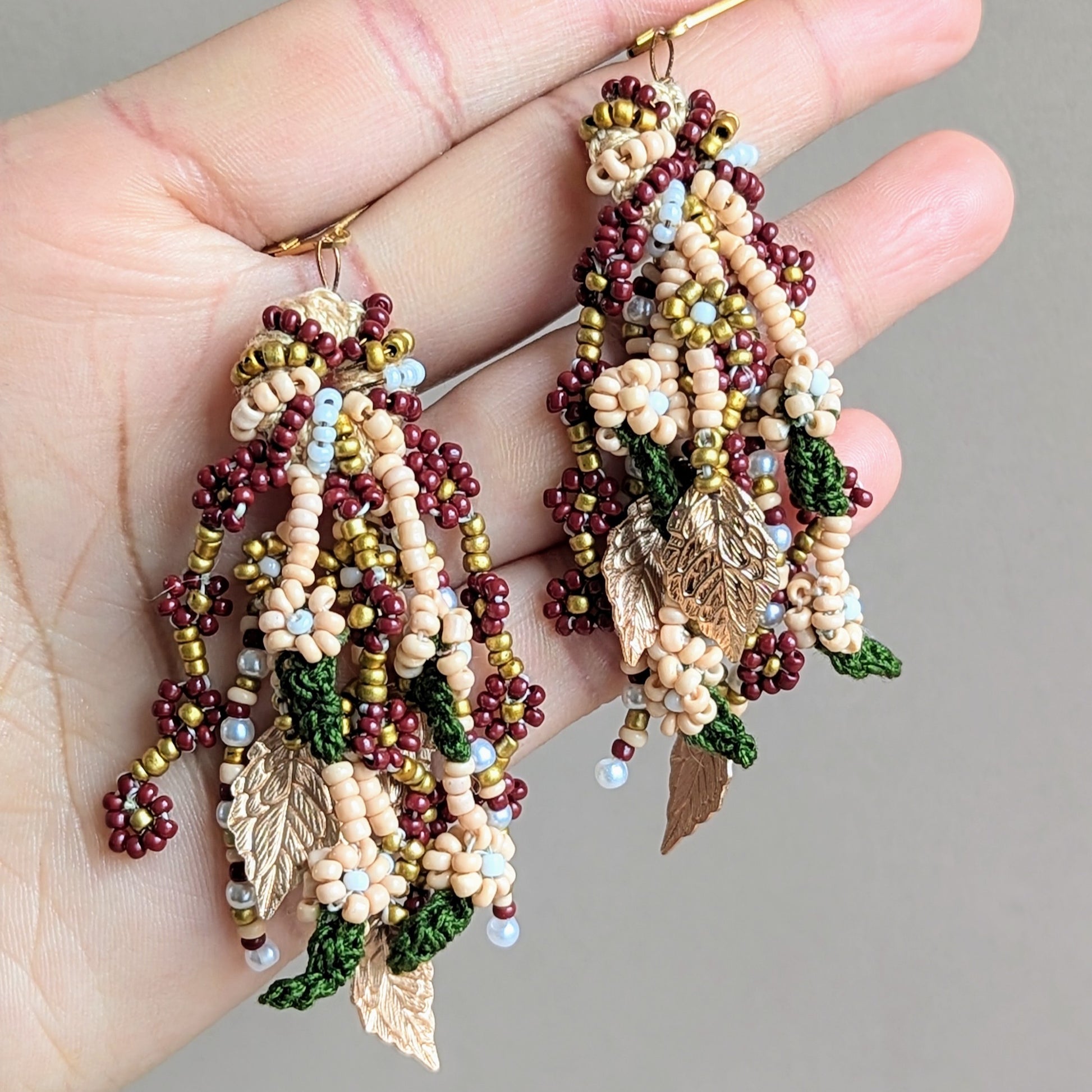 Lightweight and beautifully crafted, these earrings combine comfort with sophistication in a distinct style unique to sustainable brand Mayaani Jewellery UK. Drawing from Indian bridal aesthetics, they feature vivid red, green, and gold accents, along with seed pearls. Finished with intricate gold leaves, they reflect India’s heritage in style.