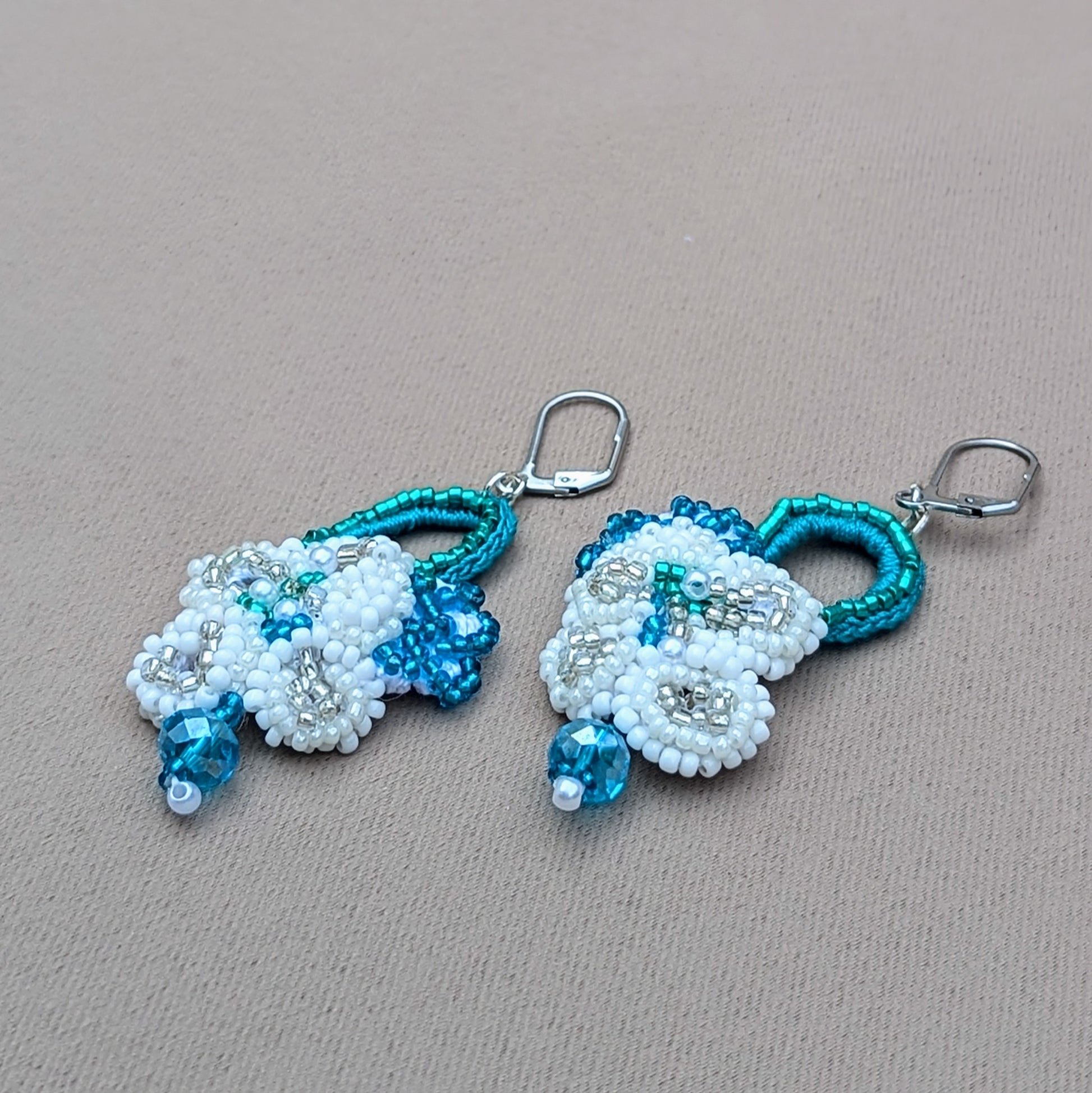 Introducing a beautiful pair of handcrafted bridal earrings from the sustainable UK brand Mayaani Jewellery. Designed with intricate hand crochet and delicate floral motifs, these earrings are finished with modern stainless steel lever back clasps and high-quality upcycled Swarovski-style bicone beads, making them the ideal "something borrowed" for your wedding day.