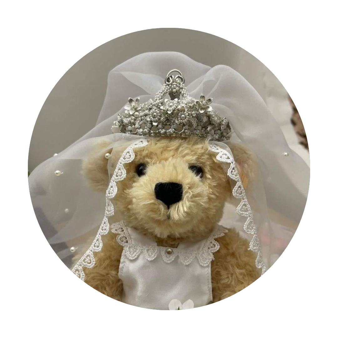 Customer photo of a teddy bear wearing a bespoke vintage Victorian style beaded silver and ivory tiara designed and handcrafted by Mayaani Jewellery UK Indian designer and artisan Megha featured alongside a bridal style veil.