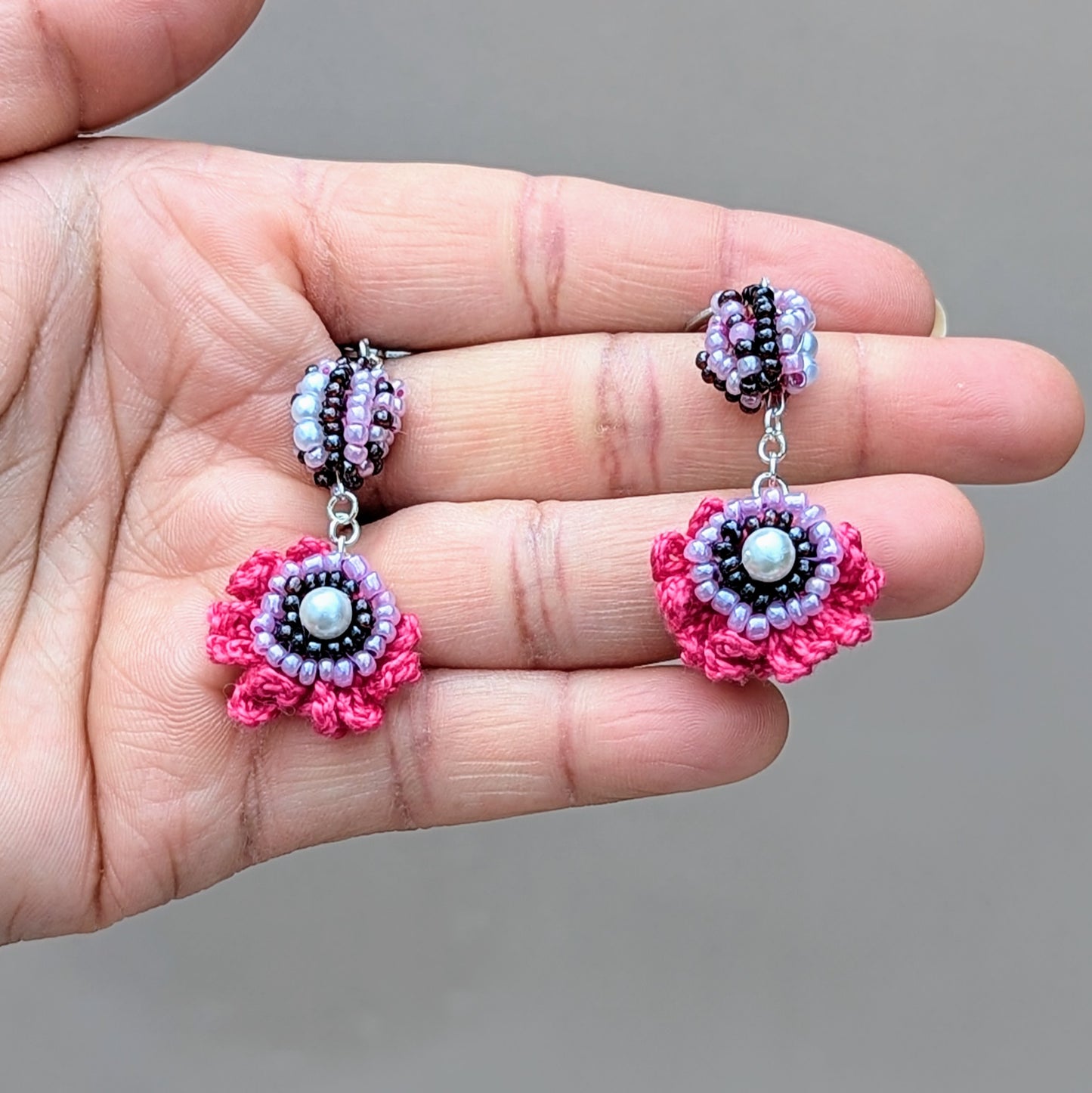 Elevate your style with these bold, handcrafted earrings from Mayaani Jewellery, a sustainable UK brand designed by Megha. This exclusive pair features her signature scrap beads and combines hand crochet, beadwork, and wire wrapping in eye-catching pink, purple, and lilac hues, finished with silver stainless steel clasp hooks. Ideal for adding a splash of colour to both special events and daily looks!