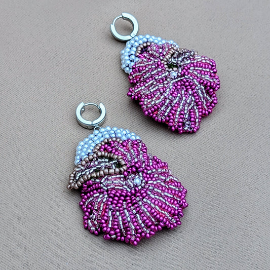 A unique, artisan handcrafted pair of intricate purple, white and silver earrings exclusively from the sustainable UK brand Mayaani Jewellery. Featuring floral motifs the earrings display vibrant and elegant beadwork for a beautiful blend of traditional craftsmanship and contemporary wedding and occasion Indian jewellery style.