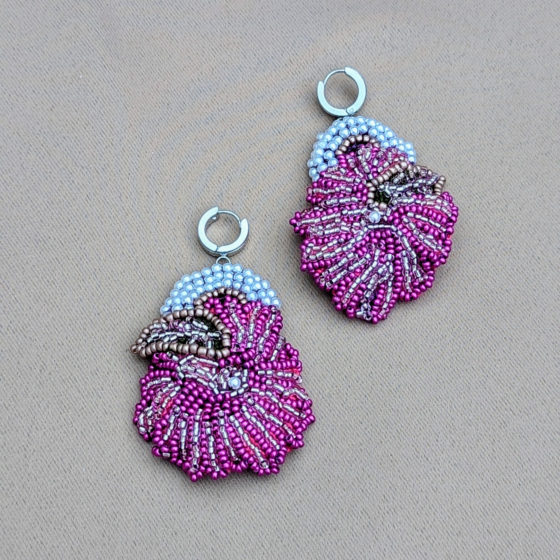 A uniquely handcrafted pair of bold daring purple, silver and white Indian earrings featuring exceptional hand beadwork and hand crochet arranged to form a striking floral motif. Exclusive to Mayaani Jewellery a sustainable UK brand, this statement design fuses traditional craftsmanship with a contemporary edge whilst maintaining a featherlight feel ensuring comfortable wear for extended periods.