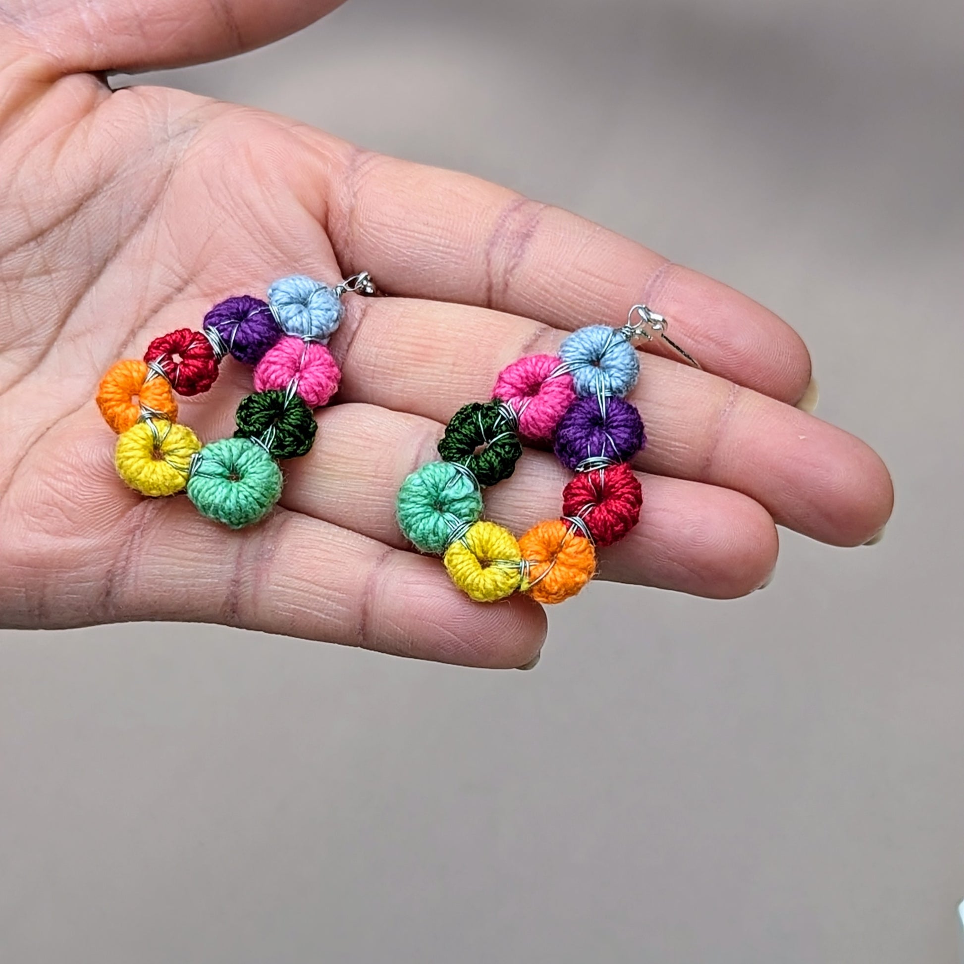 Discover the charm of these artisan teardrop-shaped rainbow earrings by sustainable UK brand Mayaani Jewellery. Each earring is meticulously handcrafted, showcasing a collection of hand-crocheted and hand-wire-wrapped circles in a dazzling array of colours. The circles are individually crocheted and wrapped in high-quality silver-plated copper wire, then artfully arranged to create a striking rainbow teardrop design. Finished with delicate sterling silver lever-back hooks.