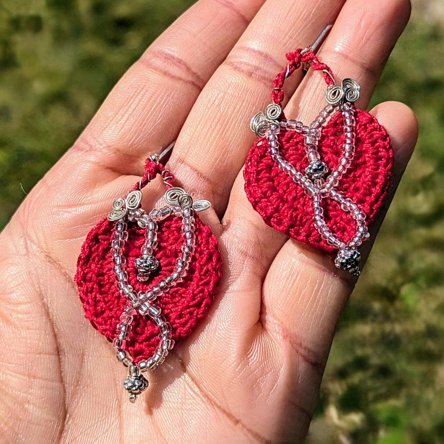 These exquisite handcrafted earrings exclusive to sustainable brand Mayaani Jewellery UK, highlight a deep red hand crochet pattern complemented by intricately placed silver lined beads, including high quality upcycled beads, and silver-plated copper wire. The 925 stamped sterling silver lever-back hooks ensure comfort and merge traditional craftsmanship with sustainable luxury for the modern eco-conscious woman.