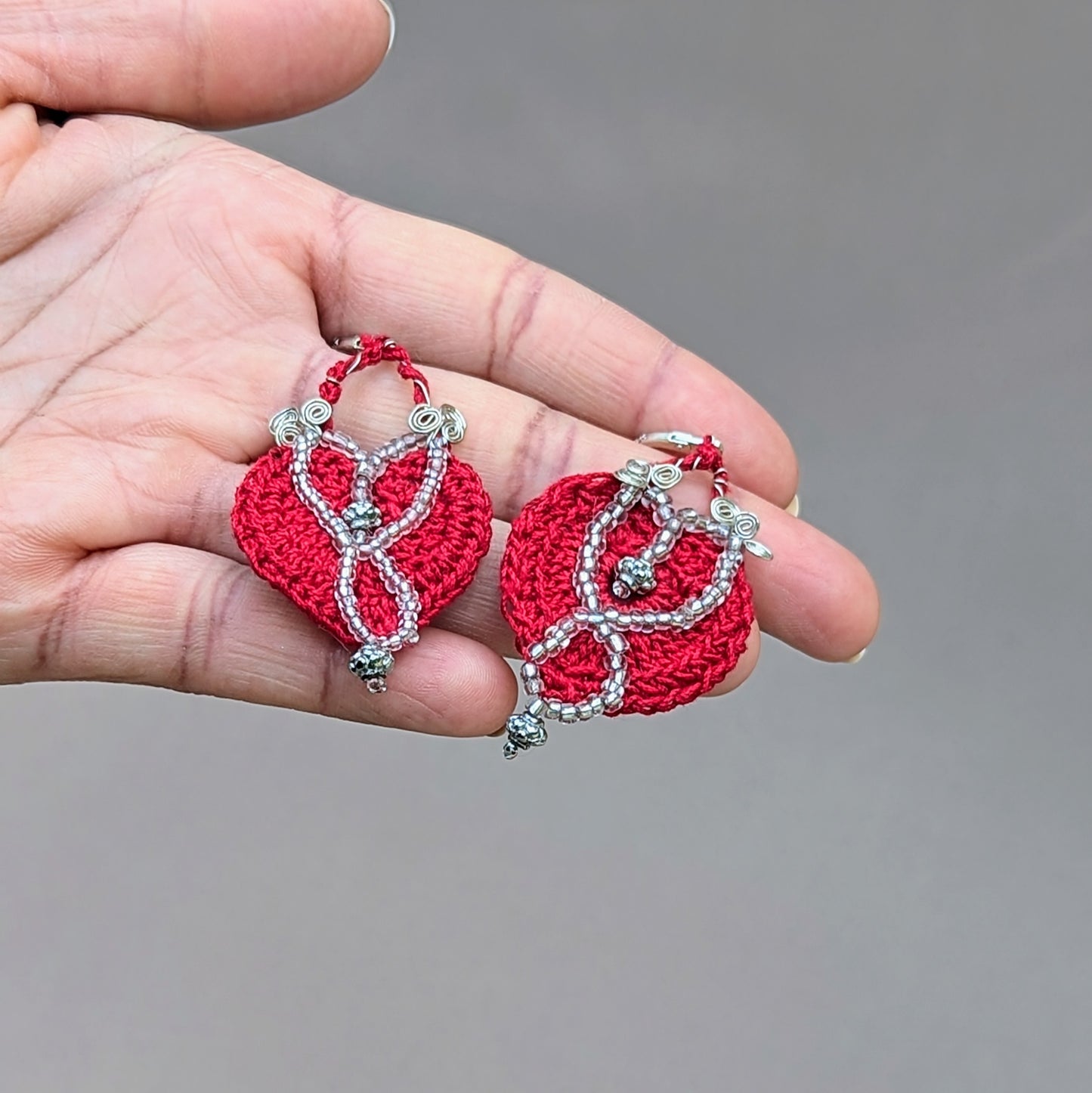 These handcrafted earrings from Mayaani Jewellery UK feature a bold red-crochet design paired with high quality upcycled beads, silver lined beads and intricate silver-plated copper wire work. Elegantly finished off with 25 stamped sterling silver lever back hooks they are a perfect blend of sustainability and style, reflecting Mayaani Jewellery's commitment to eco-friendly craftsmanship.