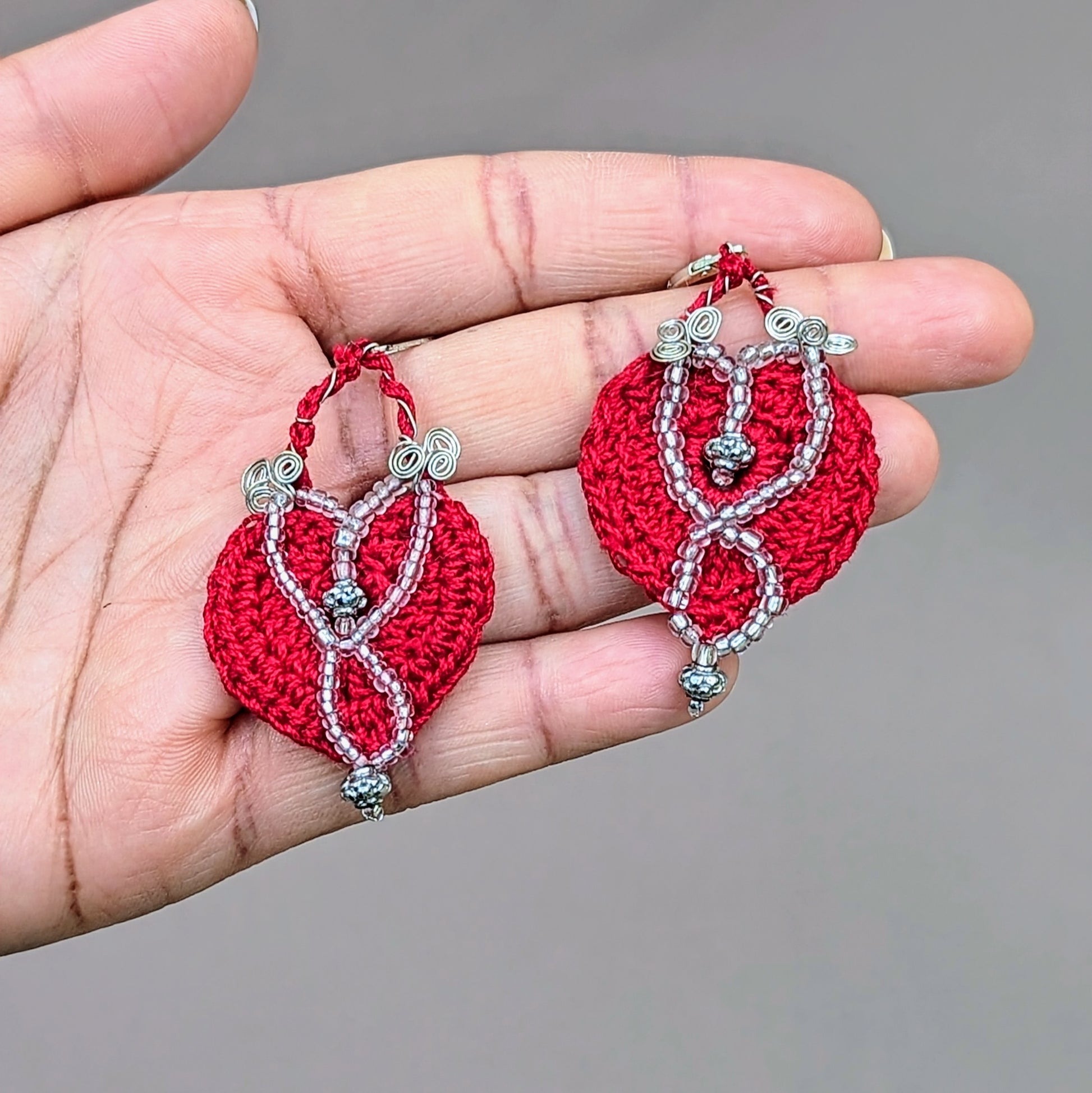 These exquisite handcrafted earrings, exclusive to Mayaani Jewellery UK, highlight a deep red crochet pattern complemented by silver-plated copper wire and intricate bead accents including high quality upcycled beads. The 925 stamped sterling silver lever-back hooks ensure comfort and quality, making these eco-friendly earrings a perfect statement piece.