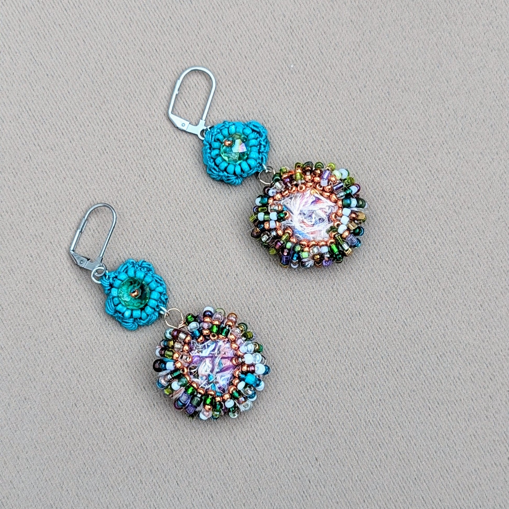 Beautiful sustainable scrap bead earrings by Mayaani Jewellery UK, drawing inspiration from crystal-clear ocean waters and Indian design. Each earring showcases a large circular scrap bead, carefully handcrafted from remnants of the jewellery-making process, and features an array of vibrant upcycled seed beads. A charming hand-crocheted turquoise flower motif, accented with an upcycled Swarovski-style bicone bead, adds the finishing touch. Ideal for weddings and occasions, they also enhance everyday outfits