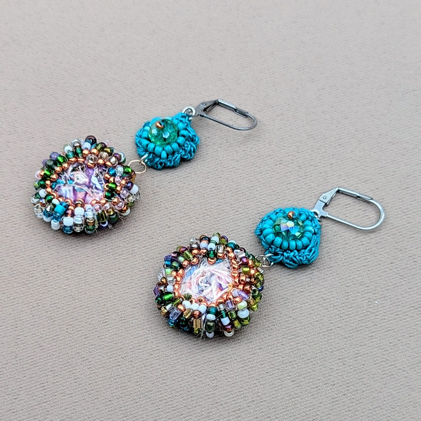 Sustainable scrap bead earrings from Mayaani Jewellery UK, inspired by ocean waters and Indian design. Each earring features a handcrafted circular scrap bead (created from jewellery making waste) and upcycled seed beads, topped with a turquoise flower motif. Perfect for weddings and everyday wear.